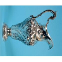 A William IV Silver Milk Jug, crested and initialled, with acanthus leaf capped "S" scroll handle, a