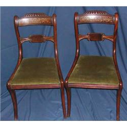 A set of four Regency mahogany and inlaid rosewood bar back dining chairs on sabre supports...