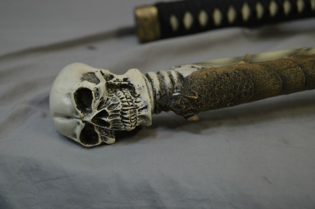 Three replica swords including shot gun motif sword and sheath