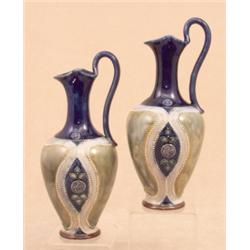 A pair of Royal Doulton pottery ewers, circa 1910, of slender ovoid form, with oval stylised flor...