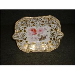 Un plat à gâteaux en porcelaine anglaise, vers 1840, à décor de roses sur fond blanc, chamois et...