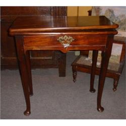 Une table à jeux Queen Ann en acajou, vers 1750, le plateau rectangulaire dépliant repose sur un...