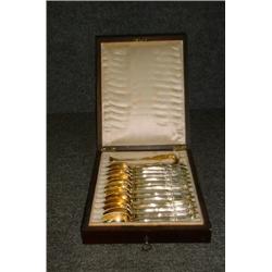 Un ensemble de 12 cuillères à thé et d'une pince à sucre en vermeil, dans un écrin en palissandre...