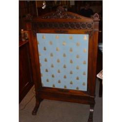 Un écran de cheminée en acajou, vers 1840, le fronton triangulaire au-dessus d'un bandeau repercé...