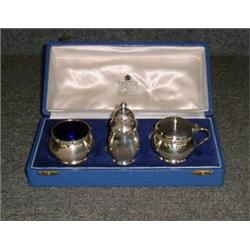 Un service à condiments de 3 pièces en argent comprenant une salière, un poivrier et un moutardie...