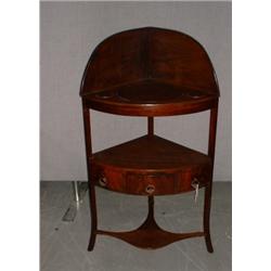 Un meuble de toilette d'angle en acajou, vers 1800, le plateau évidé au-dessus d'un tiroir sur de...