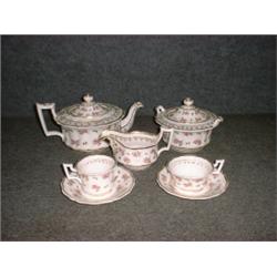 Une partie de service à thé en porcelaine anglaise vers 1850 à décor de fleurs roses sur fond bla...