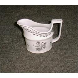 Un crémier en porcelaine de Newhall, vers 1830, à décor fleuri sépia sur fond blanc....