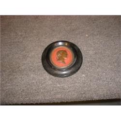 Un médaillon en métal à l'effigie de Napoleon Ier....