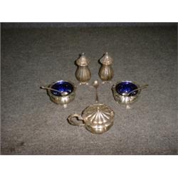 Un service à condiments de 5 pièces en argent, comprenant 2 salières, 2 poivriers et un moutardie...