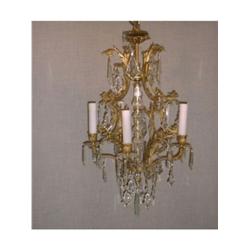 Un lustre de style Louis XV en bronze doré à 5 branches de lumière à décor de pendeloques de cris...