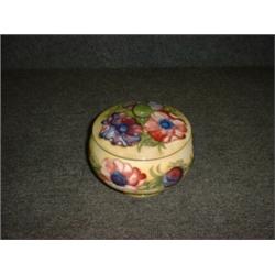 Un pot à tabac couvert en poterie de Moorcroft à décor fleuri sur fond jaune, (cheveu)....