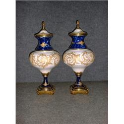 Une paire d'urnes couvertes en porcelaine dans le gout de Sèvres, à décor de rinceaux dorés sur f...