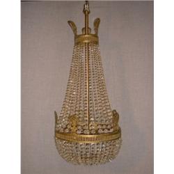 Un lustre de style Louis XVI en forme de poire en bronze doré et cristal....