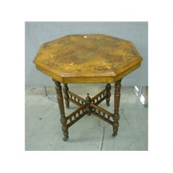 Un guéridon octogonal en loupe de noyer, le plateau marqueté d'urnes et de feuillage sur des pied...