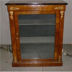 Une vitrine en noyer partiellement noirci, d'époque victorienne, munie d'une porte vitrée sur une...