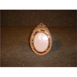 Un encadrement de photo ovale en métal doré serti d'écaille véritable....