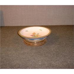 Un bol en porcelaine à décor de fleurs dans une monture en métal doré, (cheveu)....