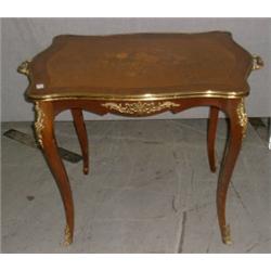 Une petite table de style Louis XV en bois de placage, sur des pieds cambrés....