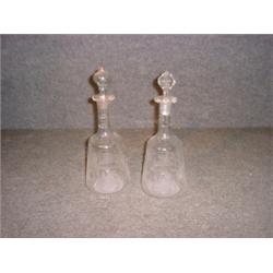 Une paire de carafes en verre gravées de griffons, (un bouchon remplacé)....