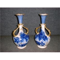 Une paire de vases en porcelaine "flow blue" à décor fleuri, les anses dorées, par William Alsaye...