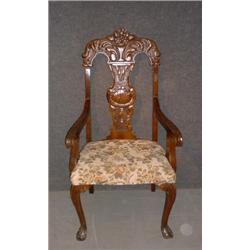 Une chaise d'entrée en acajou de style Chippendale, le dossier sculpté d'une urne fleurie et d'un...