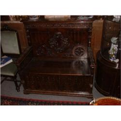 Un banc-coffre du 19e Siècle en chêne dans le goût de la Renaissance, le dossier sculpté d'un écu...