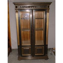 Une vitrine victorienne en bois noirci partiellement dorée, la corniche moulurée au-dessus d'un b...