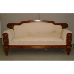 Un divan edwardien en acajou, le dossier et les montants découpés marquetés de rinceaux....