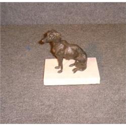 Un sujet en bronze patiné représentant un lévrier assis....