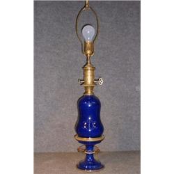 Une lampe à huile piriforme en porcelaine bleu cobalt, ornements de métal doré, électrifiée....
