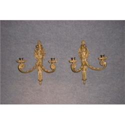 Une paire d'appliques de style Louis XVI en bronze doré à 2 branches de lumière décorées de têtes...