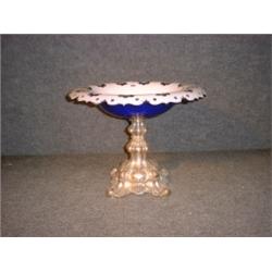 Un centre de table du milieu du 19e Siécle, la coupe en verre bleue et blanche sur une base en mé...