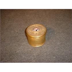 Une boîte en métal doré, le couvercle orné d'un médaillon émaillé représentant une jeune femme en...