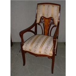 Un fauteuil Art Nouveau en acajou, le dossier ajouré sculpté de fleurs et marqueté d'iris, sur de...