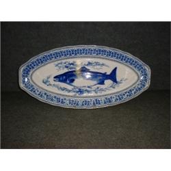Un plat à poisson en porcelaine de Royal Doulton, vers 1900, à décor bleu de brochet et de frise...