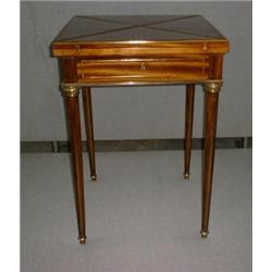 Une table à jeux en acajou à filets de laiton doré, le plateau pivotant se déplie en quatre parti...