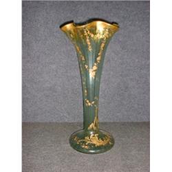 Un vase cornet en verre à décor doré de feuilles et de fleurs sur fond vert....