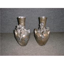 Une paire de vases Art Nouveau en étain à décor de nymphes et de chérubins, (un accidenté)....