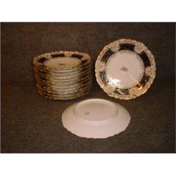 Un ensemble de 12 assiettes à dessert en porcelaine autrichienne à décor de fleurs sur fond bleu...