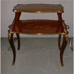 Une table à deux plateaux de style Louis XV en marqueterie à décor fleuri sur des pieds cambrés....