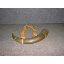 Une poire à poudre en corne à monture de laiton à décor repoussé géométrique....