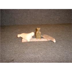 Un groupe sculpté inuit en os de baleine et stéatite représentant un ours, un phoque et une balei...