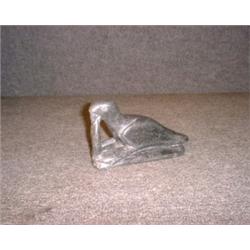 Une sculpture inuit en stéatite représentant un phoque se nourissant d'un poisson, signée: "Semeo...