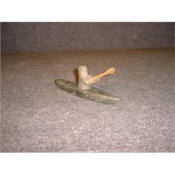 Une sculpture inuit en stéatite représentant un esquimeau dans son kayak....