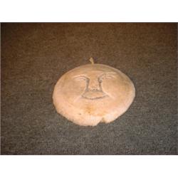 Une sculpture inuit en os de baleine représentant un visage....