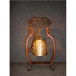 Un gong chinois en bronze sur un support en bois sculpté ajouré....