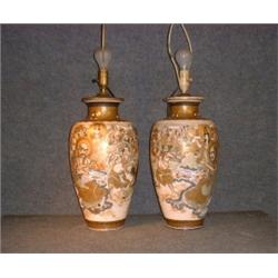 Une paire de vases en poterie de Satsuma, vers 1900 à décor de personnages, (électrifiés)....