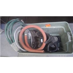 Plastic tub with miscellaneous work boots, garden hose, etc