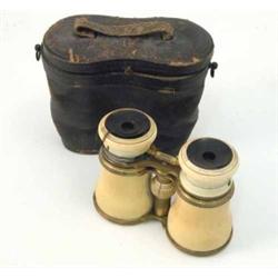 A pair of late 19th century ivory and gilt brass opera glasses/binoculars, with three interchange...
